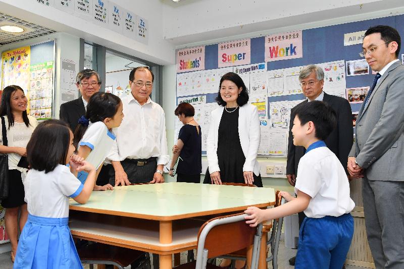 The Secretary for Education, Mr Eddie Ng Hak-kim (third left), visits the English activity room of Shatin Tsung Tsin School today (July 18) and chats with students.