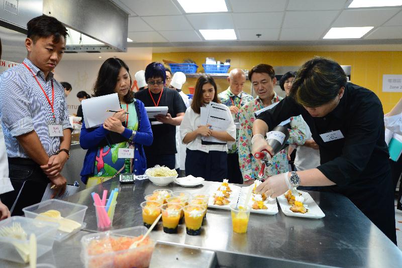 美食车先导计划「烹饪挑战赛」昨日（七月二十六日）在中华厨艺学院举行，旅游事务专员朱曼铃（左二）和其他评审委员会成员一同评审入围申请者（右一）示范的招牌菜。