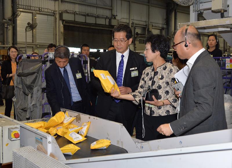 The Secretary for Commerce and Economic Development, Mr Gregory So (third right), accompanied by the Postmaster General, Mrs Jessie Ting (second right), learns about the operation of the Packet Sorting Machine during his visit to the Air Mail Centre of Hongkong Post at the Hong Kong International Airport today (August 11).