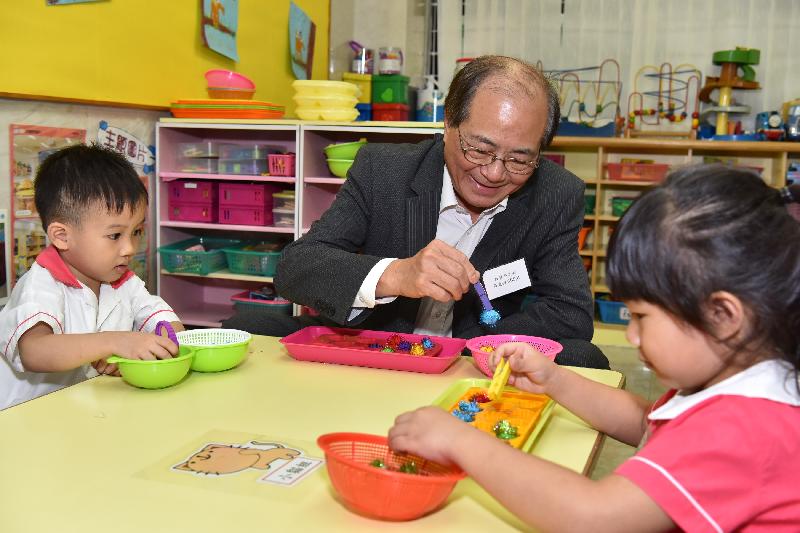 The Secretary for Education, Mr Eddie Ng Hak-kim (centre), today (August 29) visited Po Leung Kuk Li Tsui Chung Sing Memorial Kindergarten. Photo shows Mr Ng taking part in a fine motor skill activity with students.
