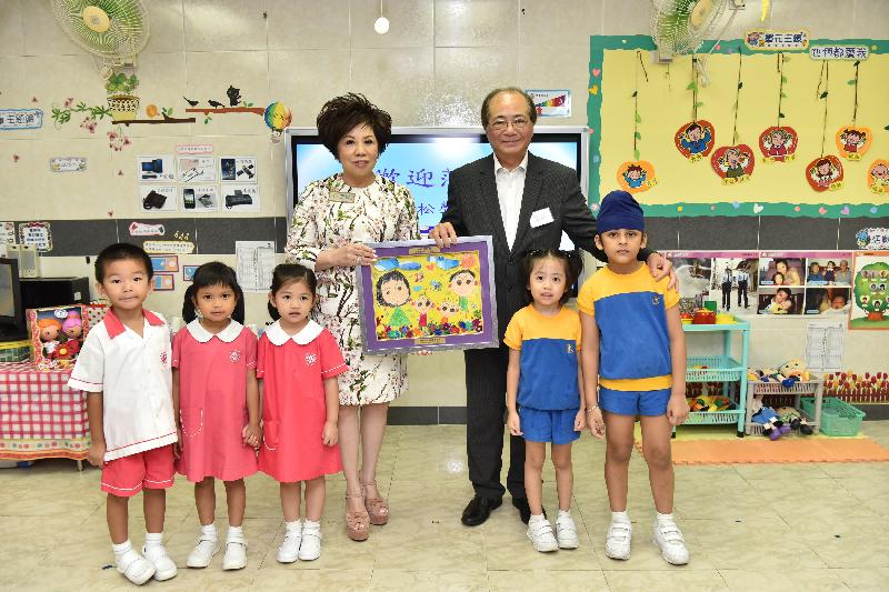 The Secretary for Education, Mr Eddie Ng Hak-kim (back row, right), is presented with a drawing by the students of Po Leung Kuk Li Tsui Chung Sing Memorial Kindergarten today (August 29).