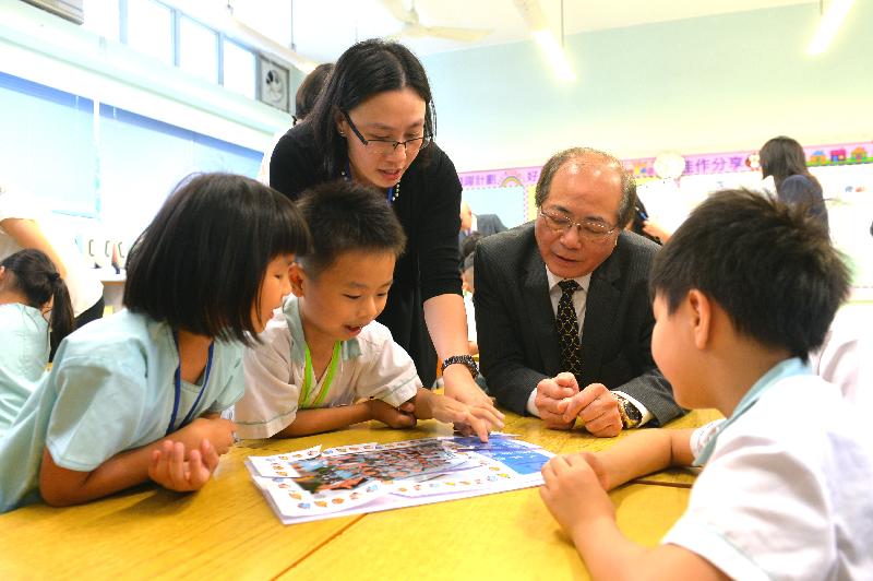教育局局长吴克俭（右二）今日（九月一日）探访天水围循道卫理小学，与学生合力完成拼图。