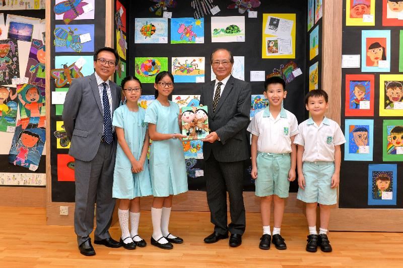 教育局局长吴克俭（右三）今日（九月一日）获天水围循道卫理小学的学生致送纪念品。
