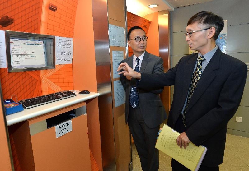 公务员事务局局长张云正（左）今日（九月二十二日）听取土地注册处人员介绍自助查册终端机。
