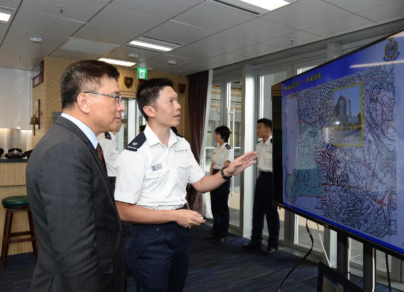 The Secretary for Financial Services and the Treasury, Professor K C Chan (left), is briefed on facilities of the new Yau Ma Tei Police Station today (September 22).