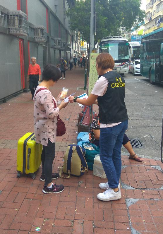 香港海關於十一國慶期間展開名為「阿加斯」的巡查行動，加強對旅客的消費保障，包括巡查旅行團安排的購物點和參茸海味、藥房及珠寶首飾等店鋪。圖示海關人員向旅客派發宣傳單張。