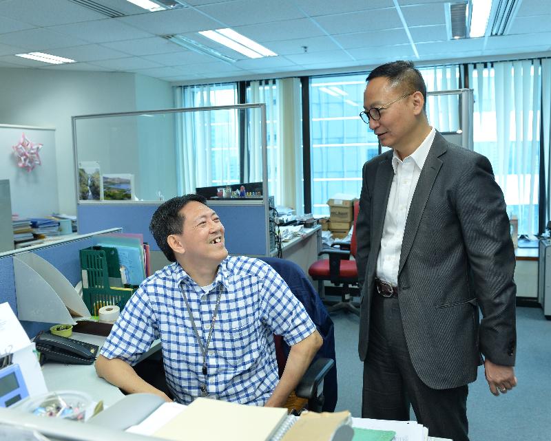 The Secretary for the Civil Service, Mr Clement Cheung (right), today (October 6) speaks with one of several persons with disabilities employed at the Companies Registry to learn more about his daily duties and work experience.