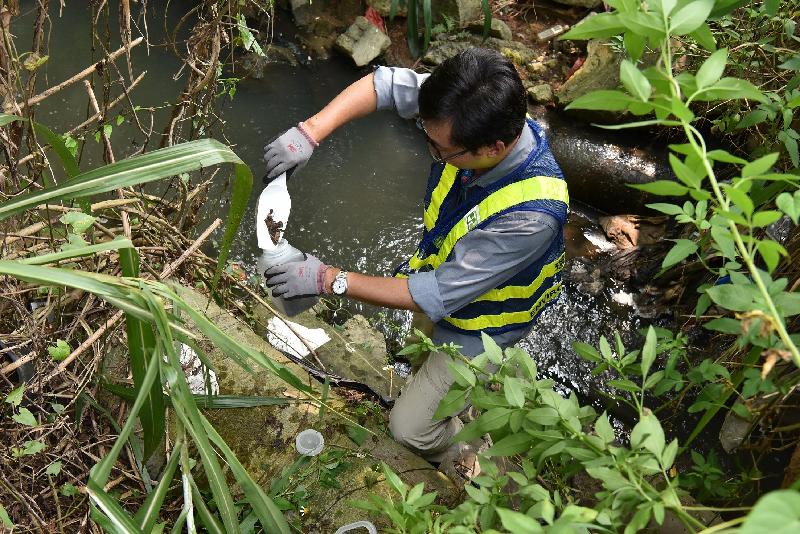 During a joint operation on open recycling sites in Hung Lung Hang in North District held between September 26 and October 4, an Environmental Protection Department officer collects water and soil samples at a nearby area.