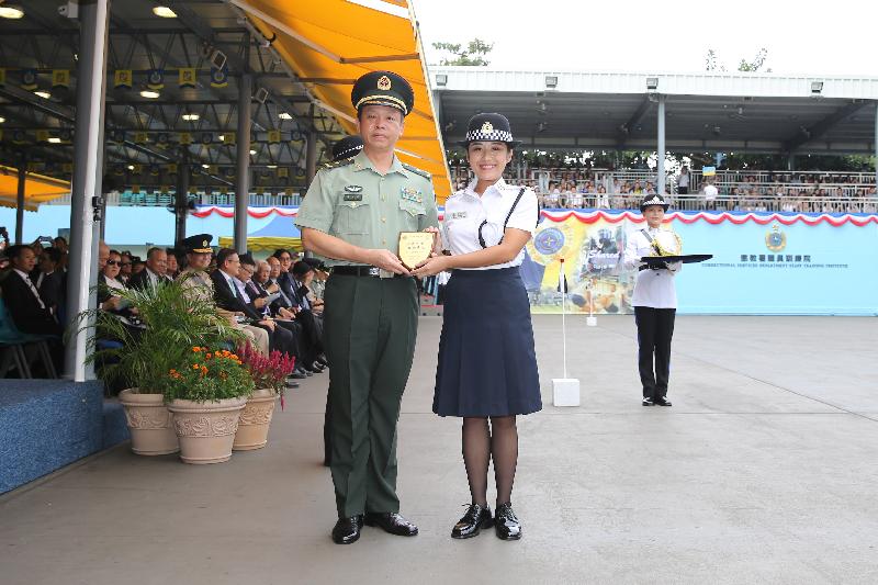 The Deputy Commander of the Chinese People's Liberation Army Hong Kong Garrison, Major General Liao Zhengrong (left) presents a Best Recruit Award, the Principal's Shield, to Officer Ms Wong Wing-tung while attending the Correctional Services Department (CSD) passing-out parade at the Staff Training Institute of the CSD in Stanley today (October 7).