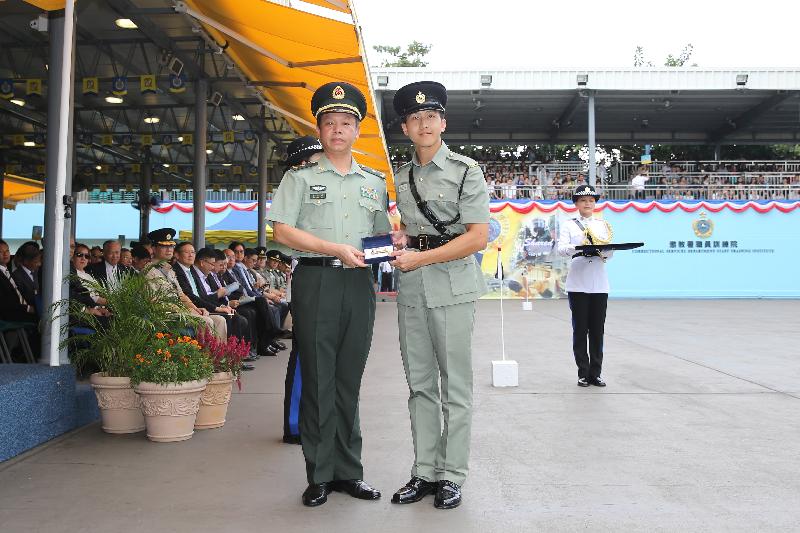 The Deputy Commander of the Chinese People's Liberation Army Hong Kong Garrison, Major General Liao Zhengrong (left), presents a Best Recruit Award, the Golden Whistle, to Assistant Officer II Mr Tang Man-ho while attending the Correctional Services Department (CSD) passing-out parade at the Staff Training Institute of the CSD in Stanley today (October 7).