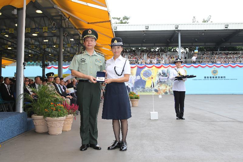 The Deputy Commander of the Chinese People's Liberation Army Hong Kong Garrison, Major General Liao Zhengrong (left), presents a Best Recruit Award, the Golden Whistle, to Assistant Officer II Ms Tong Lai-sho while attending the Correctional Services Department (CSD) passing-out parade at the Staff Training Institute of the CSD in Stanley today (October 7).