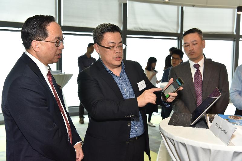 創新及科技局局長楊偉雄（左）今日（十月十九日）在數碼港聽取數碼港培育計劃公司TNG Wallet的管理層介紹其電子錢包的運作。旁為香港數碼港管理有限公司行政總裁林向陽（右）。