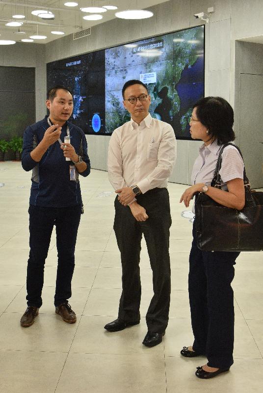 The Secretary for the Civil Service, Mr Clement Cheung, leading a delegation of Permanent Secretaries and Heads of Departments, visited a network service company today (October 20). Photo shows Mr Cheung (centre) and the Permanent Secretary for Education, Mrs Marion Lai (right), being briefed on the business of the company.