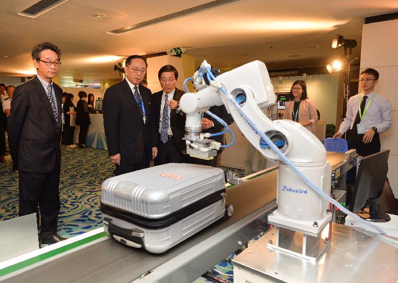 The Secretary for Innovation and Technology, Mr Nicholas W Yang (second left), views a demonstration of the Robotic Effector System for Label Affixing for handling luggage during his tour at the Hong Kong International Airport Technovation Conference and Exhibition today (November 2). The system was developed by the Hong Kong R&D Centre for Logistics and Supply Chain Management Enabling Technologies.