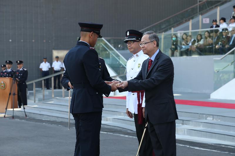 The Secretary for Security, Mr Lai Tung-kwok, reviewed the 176th Fire Services passing-out parade at the Fire and Ambulance Services Academy today (November 4). Picture shows Mr Lai (first right) presenting the Best Recruit award to a graduate.
