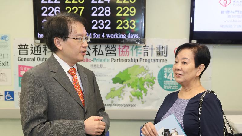 The Director (Cluster Services) of the Hospital Authority, Dr Cheung Wai-lun (left), chats with patient Ms Tong about her enrolment into the General Outpatient Clinic Public-Private Partnership Programme today (November 9).