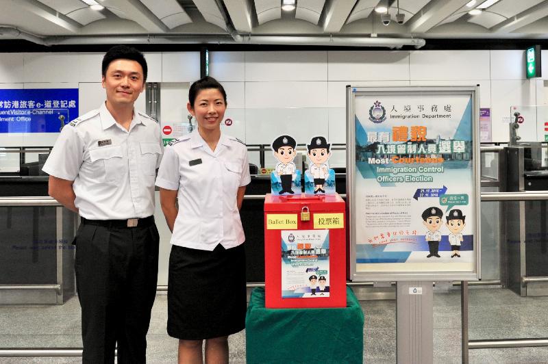 Immigration Control Officers alongside a ballot box and poster for the Most Courteous Immigration Control Officers Election.

