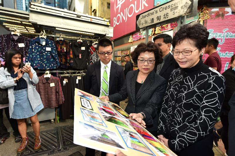 The Chief Secretary for Administration, Mrs Carrie Lam, visited Wan Chai today (December 1) and toured Jardine's Crescent. Photo shows Mrs Lam (first right) listening to a briefing by the Coordinator (Hawker Assistance Scheme) of the Food and Environmental Hygiene Department, Ms Rhonda Lo (second right); and the District Officer (Wan Chai), Mr Rick Chan (third right).