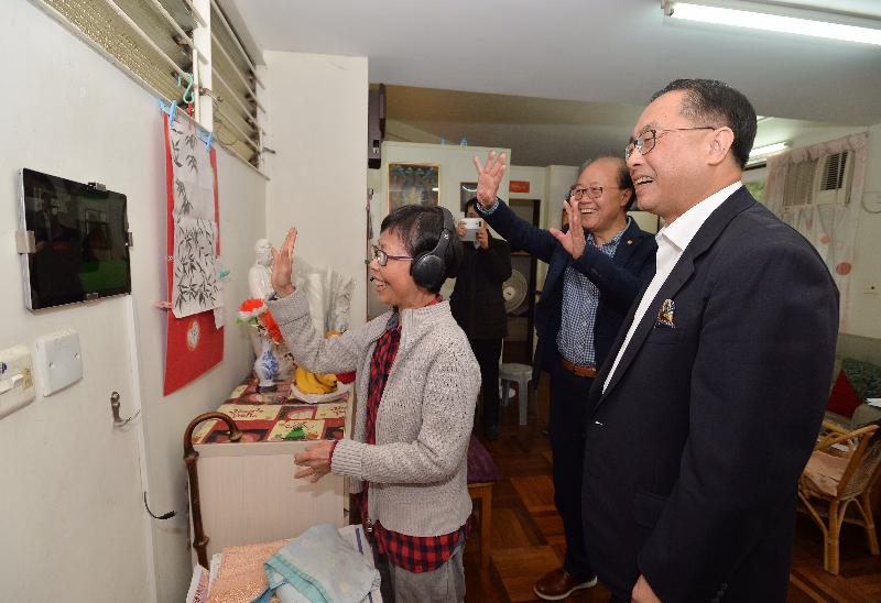 The Secretary for Innovation and Technology, Mr Nicholas W Yang (first right), visits an elderly couple living in Chung Ming Sheh in Clague Garden Estate this afternoon (December 9) to learn about how video chat technology with an estate-wide mesh Wi-Fi network helps them stay connected with neighbours.