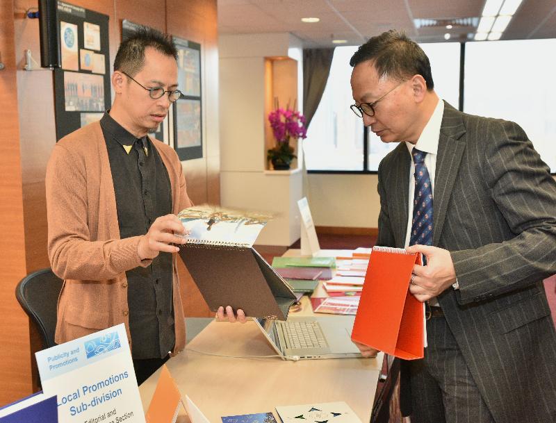 公务员事务局局长张云正（右）今日（十二月十二日）在政府新闻处与创作组的人员交谈，了解他们的日常工作。