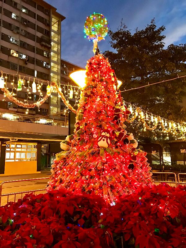 在丽阁邨设置的环保圣诞树色彩缤纷，以1 600多个饮品胶樽制作，配以圣诞灯饰及花卉，早与晚各有美态。