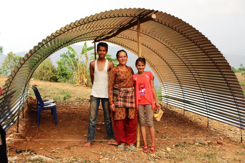 Earthquake victims in Nepal built an emergency shelter with corrugated galvanised iron sheets distributed by the relief organisation.