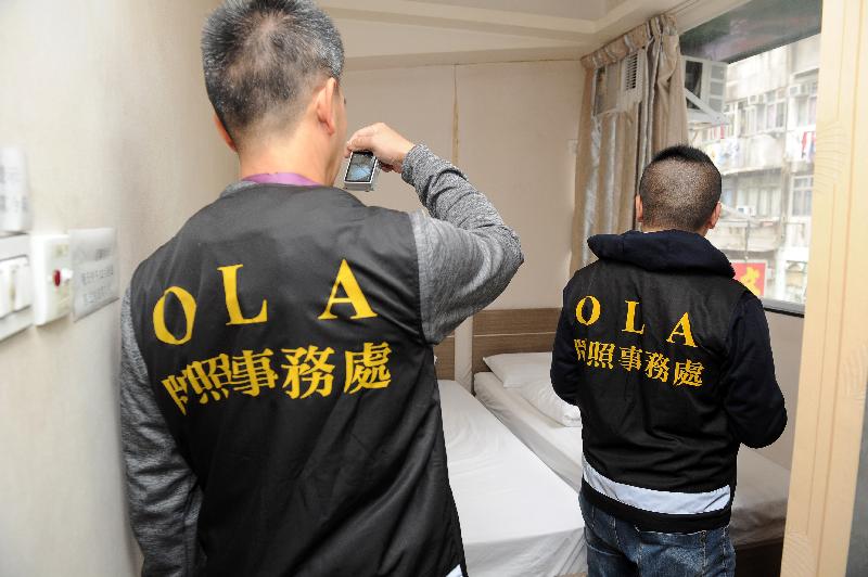 The Office of the Licensing Authority (OLA) of the Home Affairs Department stepped up law enforcement actions during the Christmas and New Year holidays to combat illegal guesthouses. Photo shows OLA officers conducting an inspection and collecting evidence inside one of the premises.