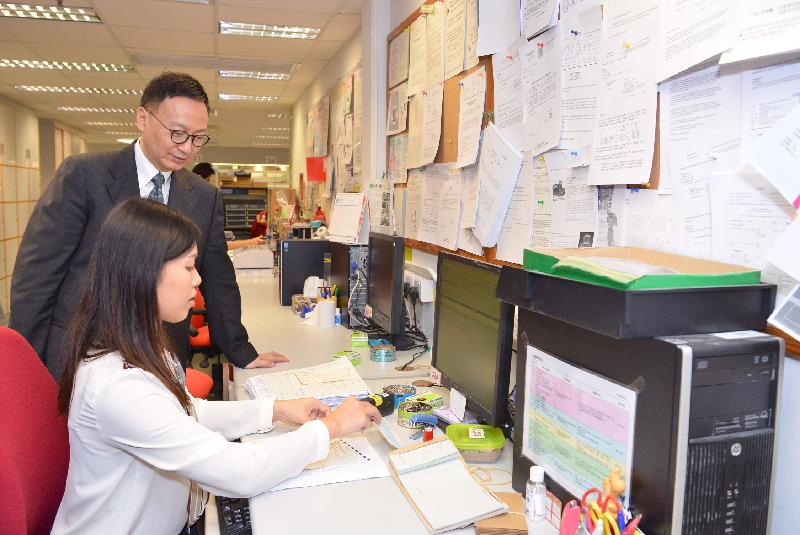 公務員事務局局長張雲正今日（一月二十日）在運輸署香港牌照事務辦事處觀看職員示範如何向市民發出、續領及吊銷車輛牌照。