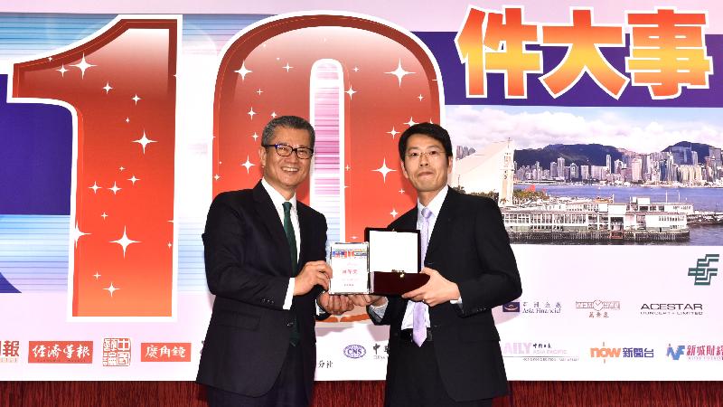財政司司長陳茂波今日（一月二十三日）出席「2016香港商界最關注的十件大事」評選頒獎典禮。圖示陳茂波（左）頒發頭獎予得獎者。