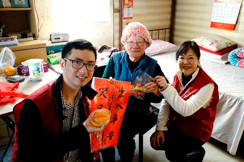 The Housing Department (HD) Volunteers Corps visited elderly tenants at Mei Lam Estate, Sha Tin last Saturday (January 21). Photo shows members of the HD Volunteers Corps giving an elderly tenant handmade fai chun and homemade festive rice cakes in the shape of golden carp.