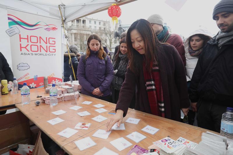 The Director-General of the Hong Kong and Trade Office, London (London ETO), Ms Priscilla To, interacts with visitors participating in traditional Hong Kong games at the London ETO's marquee in Trafalgar Square on January 29 (London time).