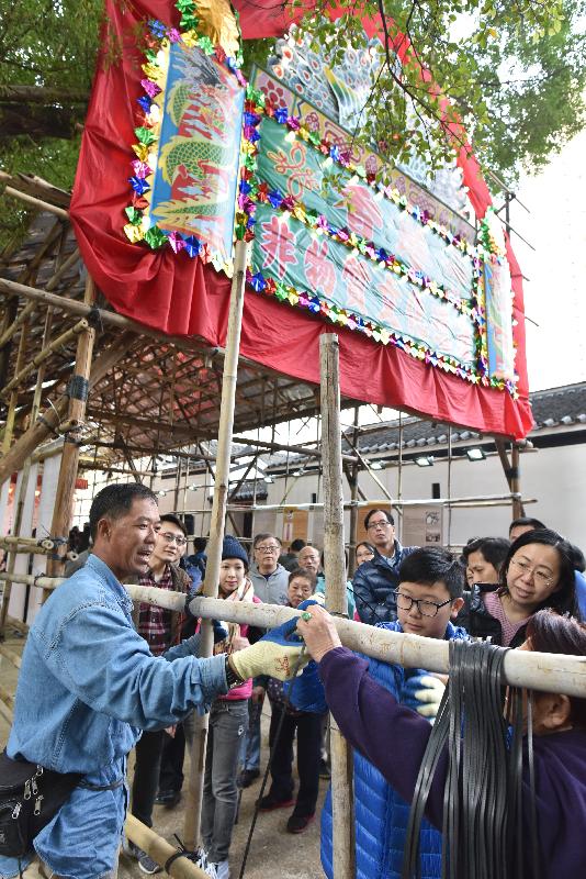 Photo shows members of public participating in the demonstration of bamboo theatre building technique.