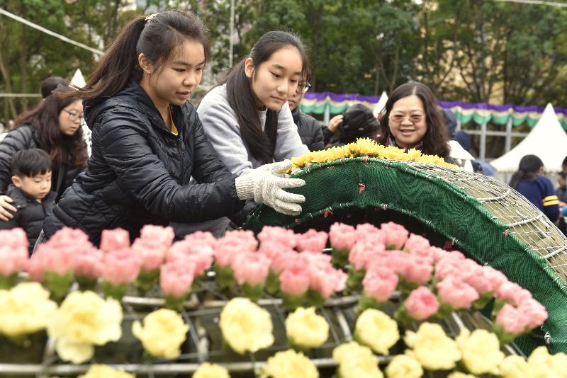 超过一千一百名来自三十六间学校的学生，今日（二月二十五日）于维多利亚公园协助镶嵌大型花坛「游园乐」。花坛展示游乐场内传统机动游戏的造型，唤起游人的快乐回忆。花坛会于即将举行的香港花卉展览中展出。