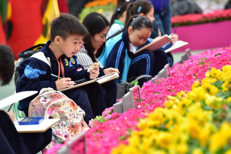 香港花卉展览今日（三月十日）在维多利亚公园开幕。参与今日绘画比赛的学童，以场内的展品为题材，发挥创意。