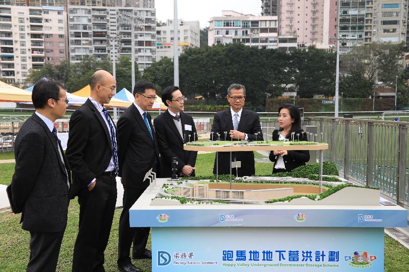 Accompanied by the Secretary for Development, Mr Eric Ma (third right), and the Director of Drainage Services, Mr Edwin Tong (third left), the Financial Secretary, Mr Paul Chan (second right), receives a briefing from an engineer of the Drainage Services Department on the Happy Valley Underground Stormwater Storage Scheme in Happy Valley today (March 16).