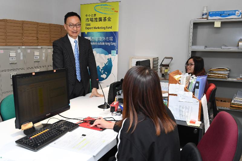 While touring the Industries Support Division of the Trade and Industry Department today (March 24), the Secretary for the Civil Service, Mr Clement Cheung (left), is briefed by front-line staff members on the processing of SME Export Marketing Fund applications and handling of enquiries.