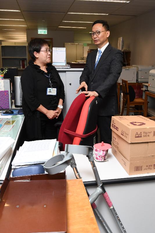 The Secretary for the Civil Service, Mr Clement Cheung (right), today (March 24) talks to one of the persons with disabilities employed at the Trade and Industry Department to learn more about her daily duties and work experience.