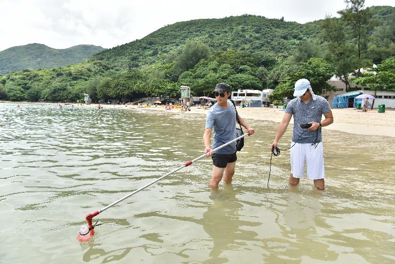 环境保护署人员在泳滩实地抽取海水样本及量度现场数据。