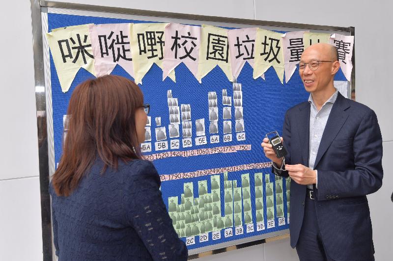 The Secretary for the Environment, Mr Wong Kam-sing (right), visits SKH Holy Cross Primary School in Kowloon City District today (April 13) to understand more on its initiatives to promote the concept of waste reduction among students.