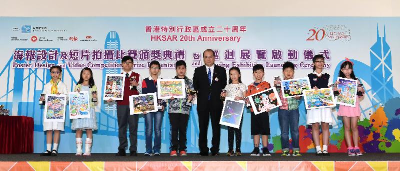 政务司司长张建宗今日（四月十四日）颁发「我到20岁时......」海报设计比赛奖项予得奖小学生，并与他们合照。
