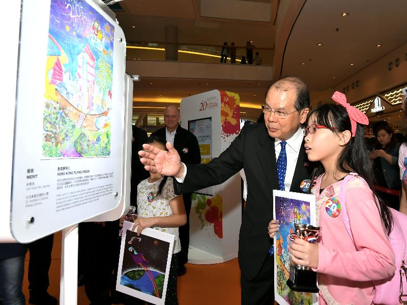 An awardee of the HKSAR 20th Anniversary Poster Design Competition today (April 14) presents her work to the Chief Secretary for Administration, Mr Matthew Cheung Kin-chung.
