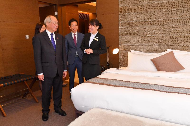 The Secretary for Education, Mr Eddie Ng Hak-kim (left) visits a room at the training hotel of the Hotel and Tourism Institute and listens to an introduction by a graduate trainee, accompanied by the Chairman of the Southern District Council, Dr Chu Ching-hong (centre).
