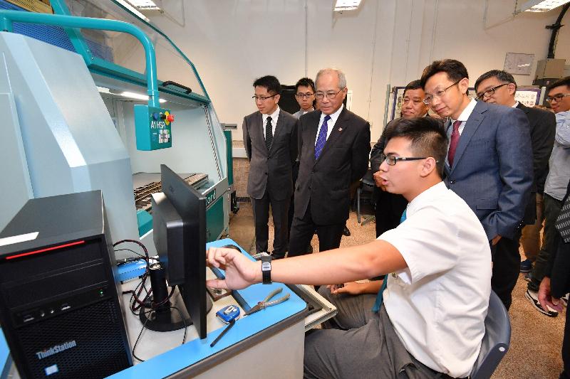 The Secretary for Education, Mr Eddie Ng Hak-kim (second left) watches a demonstration of plasma cutting at the STEM Education Centre of Aberdeen Technical School, accompanied by the Chairman of the Southern District Council, Dr Chu Ching-hong (right).