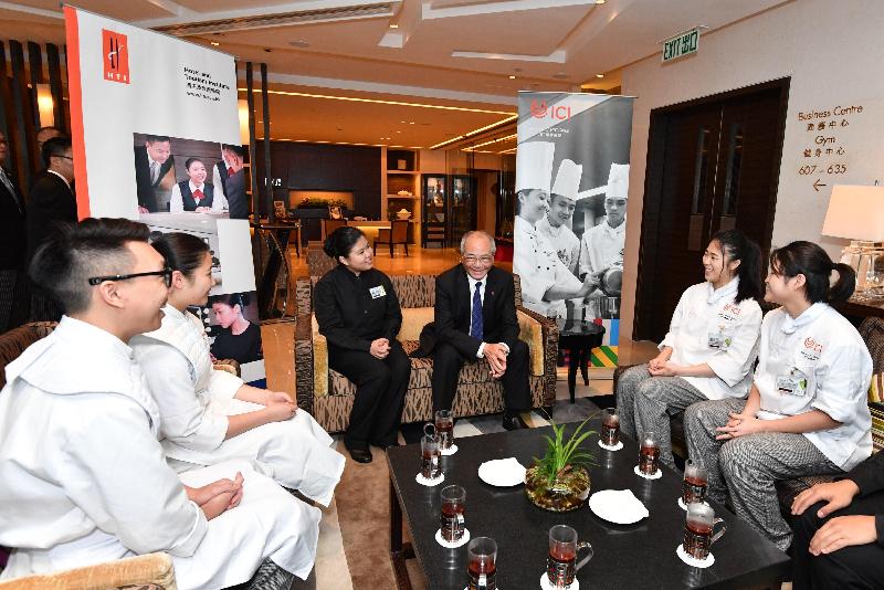 教育局局長吳克儉（中右）與酒店及旅遊學院的學生交談。
