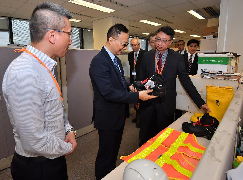 While visiting the Safety Promotion Unit of the Labour Department today (April 27), the Secretary for the Civil Service, Mr Clement Cheung (second left), is briefed by Occupational Safety Officers on the equipment they use for discharging their duties.