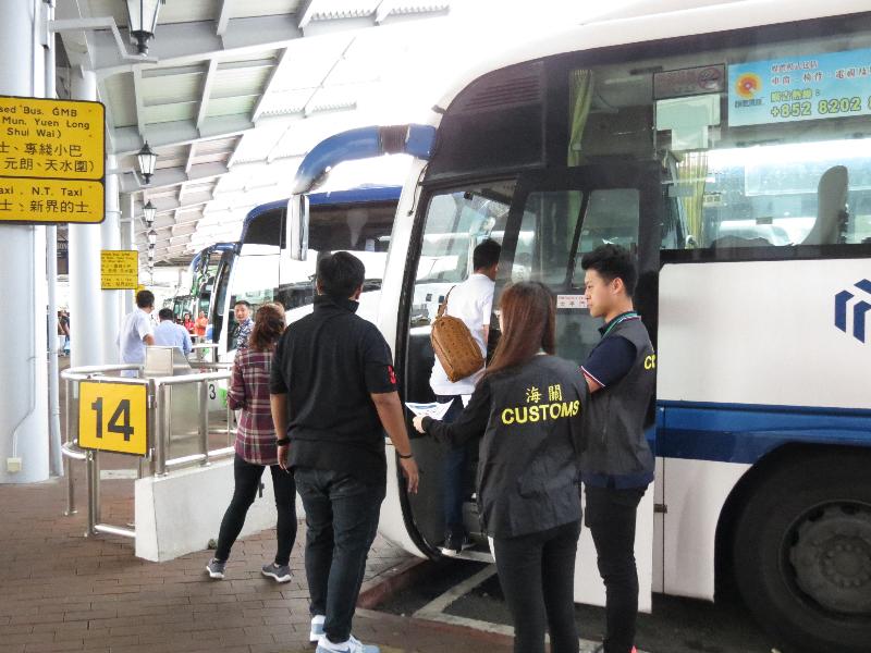 香港海关今日（四月二十七日）开展一项名为「鹰眼」的巡查行动，加强于「五一黄金周」期间对旅客的消费保障。图示海关人员在过境巴士站提醒访港旅客精明消费。