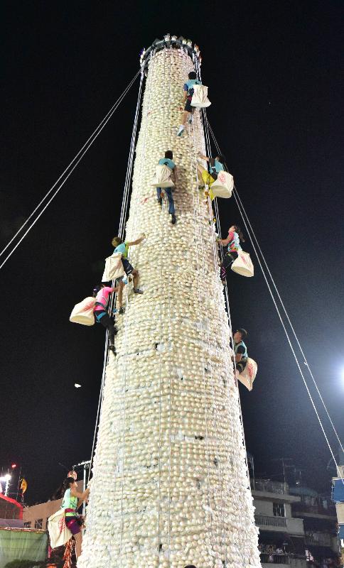 The Bun Scrambling Competition in Cheung Chau concluded early this morning (May 4). Photo shows the finalists scrambling up the bun tower to snatch as many buns as they can within a three-minute time limit to vie for the championships.
