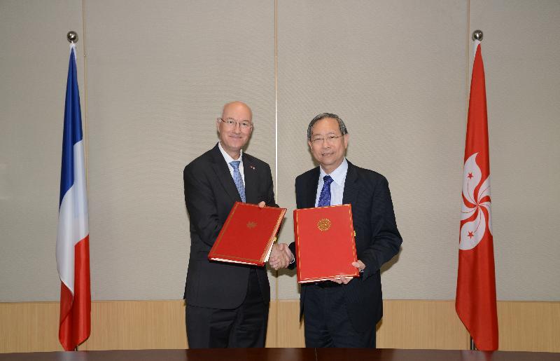 The Secretary for Security, Mr Lai Tung-kwok (right), and the Consul-General of France in Hong Kong, Mr Eric Berti (left), exchange texts after signing a bilateral agreement concerning the surrender of accused or convicted persons today (May 4).
