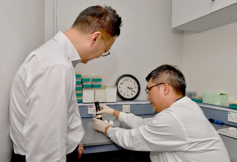 While touring the Avian Virology Laboratory in the Tai Lung Veterinary Laboratory of the Agriculture, Fisheries and Conservation Department today (May 12), the Secretary for the Civil Service, Mr Clement Cheung (left), is briefed on the inoculation of embryonated eggs for virus isolation and identification.