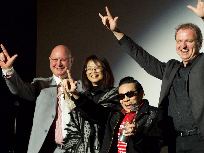香港駐紐約經濟貿易辦事處處長柏嘉禮（左一）、泰迪羅賓（右二）、亞洲躍動電影展執行董事王曉菲（左二）及芝加哥電影辦事處總監Rich Moskal（右一）於五月十一日（芝加哥時間）在芝加哥一場向泰迪羅賓致敬的頒獎晚會上合照。


